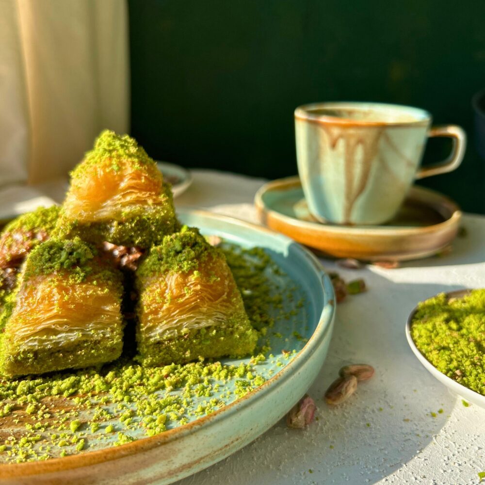 Zbliżenie na kawałek baklawy pistacjowej z widocznymi warstwami ciasta filo i pistacjami